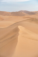 Ica desert landscape with smooth golden sand dunes near Huacachina, Peru.