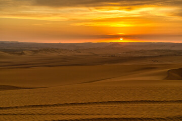 Golden sunset over the vast dunes of the Ica Desert near Huacachina, Peru.