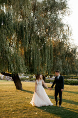 bride and groom walking in the park