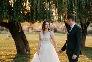 bride and groom walking in the park
