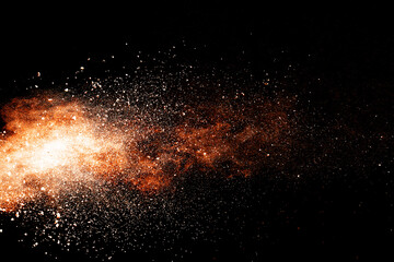 Abstract orange powder explosion isolated on black background