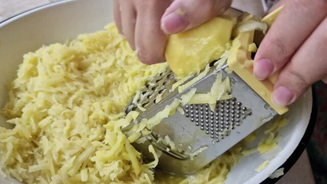 Potatoes are grated. Preparation of potato pancakes