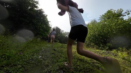 Two little girls runs in the pouring summer rain. Slow motion.