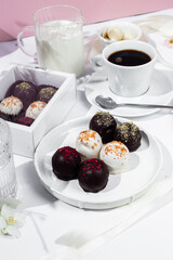 Handmade round chocolate candies on a white plate. Chocolates without sugar. Healthy dessert