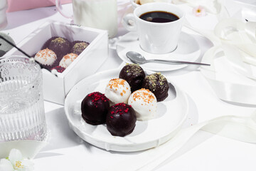 Handmade round chocolate candies on a white plate. Chocolates without sugar. Healthy dessert