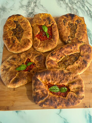 Su Mustazzeddu Typical Sardinian flatbread filled with tomato, onion, and fresh basil leaves