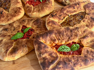 Su Mustazzeddu Typical Sardinian flatbread filled with tomato, onion, and fresh basil leaves