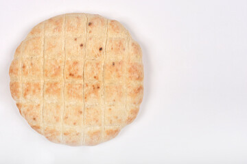 A single round flatbread with a grid pattern and light browning is centered on a white background