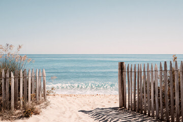 a wooden fence on a beach next to the ocean
