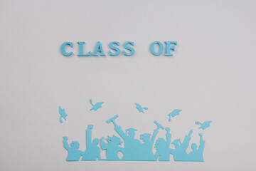 A vibrant silhouette of graduates celebrating with raised arms and flying caps against a light...