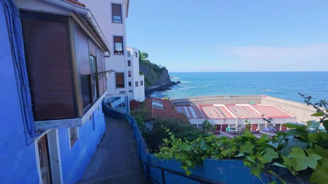 Typical street of Bermeo with views of the Cantabrian Sea and coastal vegetation, traditional Basque architecture in seaside environment, 4K footage from pedestrian perspective, northern coast of Spai