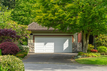Garage door in luxury house with trees and nice landscape in Spring in Vancouver, Canada, North...
