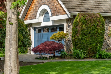 Garage door in luxury house with trees and nice landscape in Spring in Vancouver, Canada, North...
