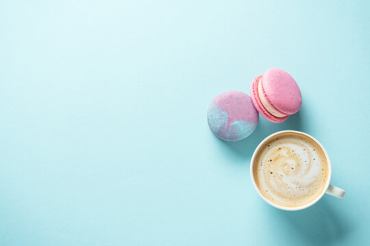 Cup of coffee and macaroon on blue background. - Powered by Adobe