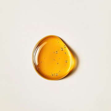 Golden yellow oil drop isolated on light background