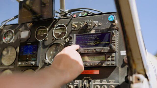 Closeup of hand running instrument checks in small light plane cockpit on clear sky sunny day in Kenya