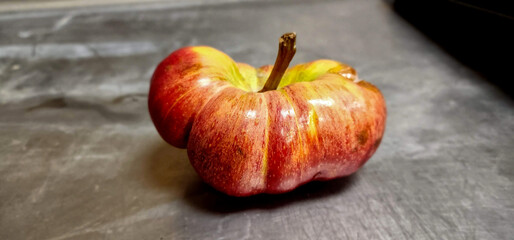 An odd shape apple that looks like a tomato