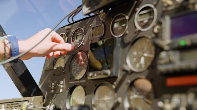 Closeup of hand running instrument checks in small light plane cockpit on clear sky sunny day in Kenya