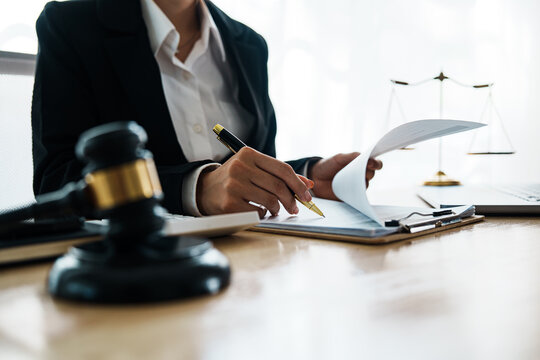 A professional lawyer advises a client in a legal office, reviewing contracts and justice symbols like a gavel and legal books