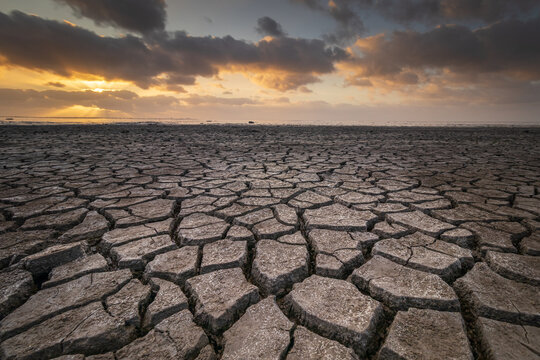Drought on the Wadden Sea Flats Under a Threatening Sky at Sunset. The cracks create striking textures in the parched mud. Stunning piece of nature, rightfully listed as a UNESCO World Heritage site.