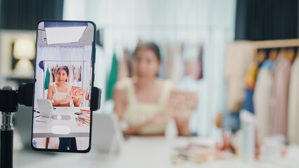 Close-up phone screen record Asia lady vlogger look phone camera review new product eye shadow palette live selling online in IG story reel tiktok work at home studio. Business online media concept.
