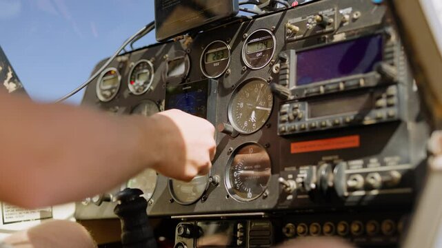 Closeup of hand running instrument checks in small light plane cockpit on clear sky sunny day in Kenya