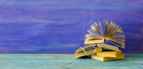 Heap of multicolored books on blue grungy background, education,knowledge is power,reading concept,...