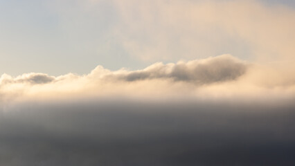 Layers of mist and clouds illuminated by the soft morning sunlight, creating a dreamy atmospheric...