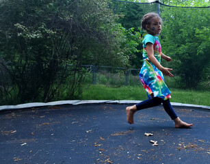 Girl walking and jumping on a trampoline