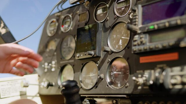 Closeup of hand running instrument checks in small light plane cockpit on clear sky sunny day in Kenya