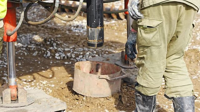 Close-up of soil sampling during pile drilling process. Extraction of subsurface material for geotechnical analysis and foundation assessment