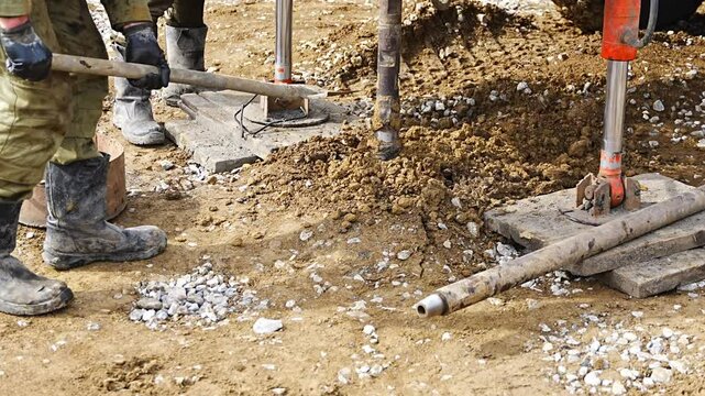 Close-up of soil sampling during pile drilling process. Extraction of subsurface material for geotechnical analysis and foundation assessment