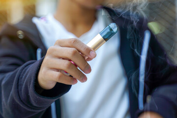 Close-up of hand holding an electronic cigarette. Soft and selective focus.