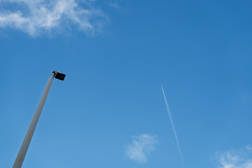晴れた日の空と街灯、飛行機雲