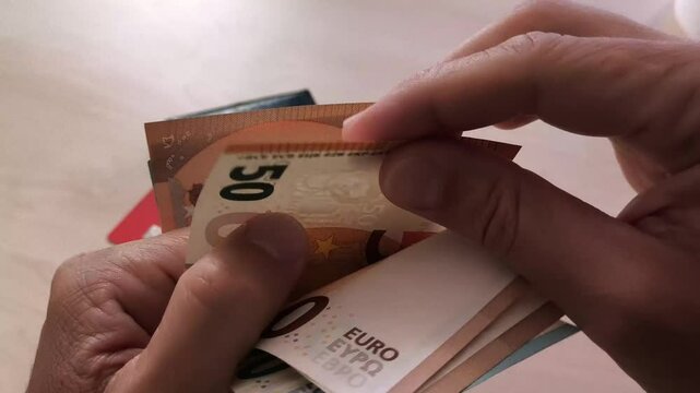 Contar dinero met&aacute;lico billete euro con las manos dedos