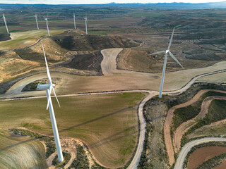 Wide aerial view of wind turbines and farmland in Zaragoza, Spain, renewable energy infrastructure highlighting terrain, roadways and sustainable power systems