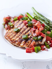 Grilled chicken fillet with asparagus and tomato salsa. Close up.