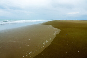 A beautiful gently sloping sandy beach, with fine sand, weak rolling waves. The Arabian Sea. Oman??...