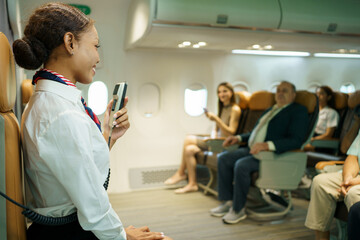 Female cabin crew is perform the flight safety demonstration before departure.