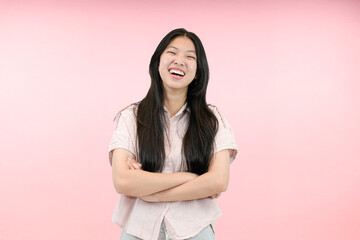 Obraz premium young asian woman arm crossed with happy expression in studio pink background