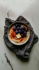 Bowl of millet porridge topped with fruits on a grey napkin  
