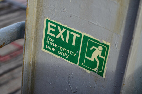 The emergency exit sticker on a bulwark of the offshore support vessel. Such stickers indicate a location of ways or equipment dedicated to be used in emergency situation on board