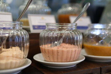 Smooth camera movement, selective focus, close-up of an assortment of sauces in white bowls on a round wooden tray. High quality 4k footage