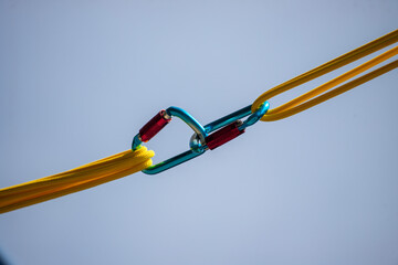 A yellow and blue rope with a blue and red clip attached to it