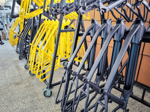 Production line of painted bicycle frames arranged on a rack in a factory