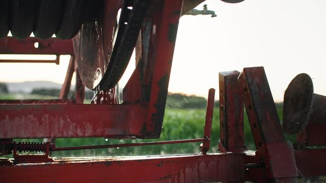 Rusty irrigation pump and old metal pipes in close-up showing leaks and signs of aging on farmland used for watering crops with outdated farming technology