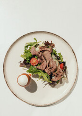 Sandwich with meat, egg and with freshly greens. Crop delicious breakfast served on wooden table in sunny cafe. Part of a series