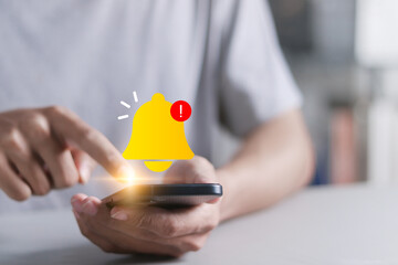Alert notification concept. Mobile error or problem, Reminder, Push Notifications. Person using smartphone with bell notification icon on virtual screen.