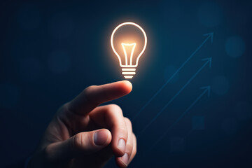 A reaching out towards an illuminated bulb symbolizes the spark innovation driving growth and strategic progress in business