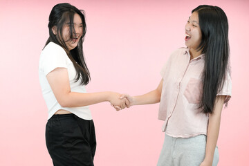 two asian woman making a deal in studio background